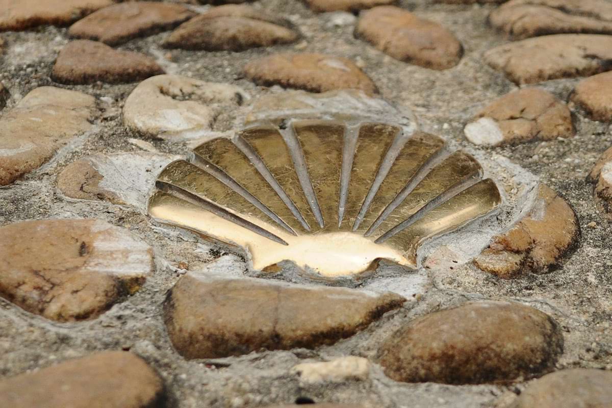 Le symbole de la coquille Saint-Jacques incrusté dans les pavés d'un chemin